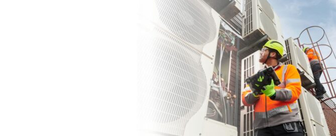 Ingeniero o técnico industrial con casco blanco y guantes, realizando una inspección en la tubería y estructura de una planta de cogeneración o petroquímica.