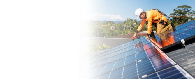 Ingeniero de energía solar usando un radio PTT y una tablet, con un condensador industrial y edificios modernos de Querétaro de fondo.
